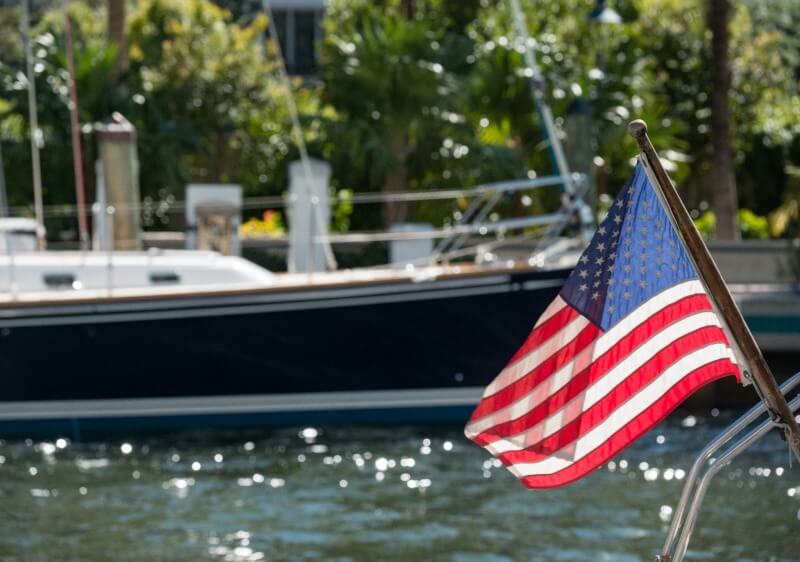 Image with US flag and yacht depicting memorial day sailing in Southern California