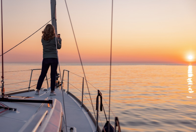 Woman taking picture of a coastal beauty in a yacht